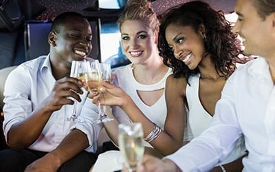 Beautiful couples toasting with champagne in a luxury limousine for Go Luxe luxury limousine service for Los Angeles and surrounding areas