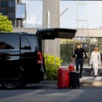 driver-helps-a-business-couple-carry-their-suitcas-2026-01-08-23-47-28-utc