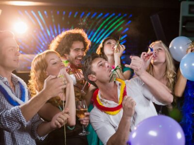 group-of-smiling-friends-blowing-party-horn-in-bar-2026-01-11-10-30-52-utc