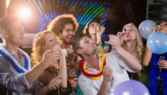 group-of-smiling-friends-blowing-party-horn-in-bar-2026-01-11-10-30-52-utc