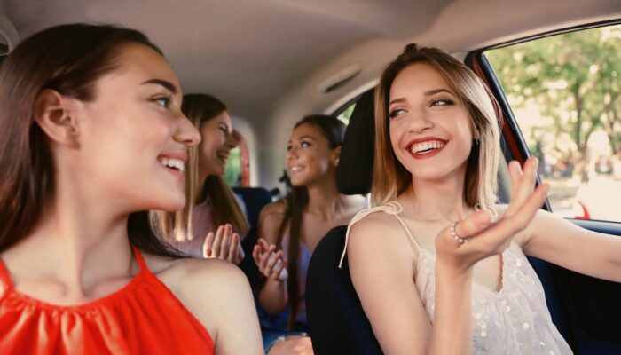 Happy beautiful young women together in car